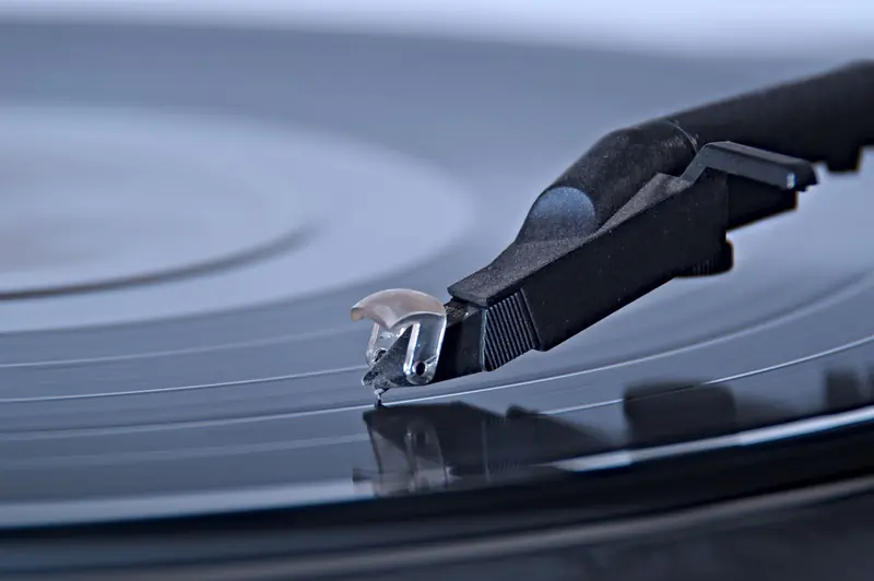 Detailed view of a turntable needle on a spinning vinyl record, capturing the essence of analog music