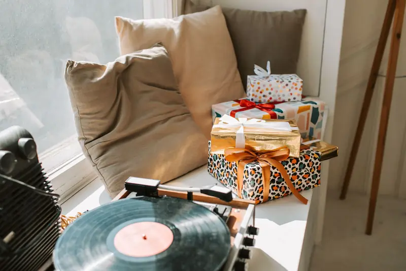 A cozy corner with gift boxes and a vinyl turntable by the window, perfect for holiday vibes