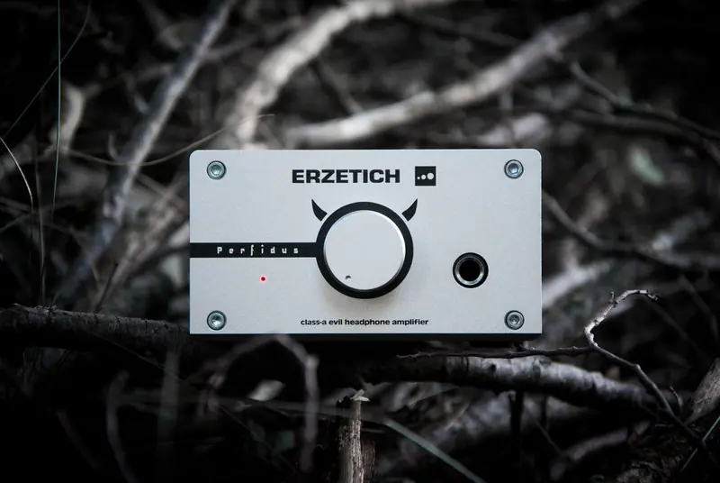 Erzetich Perfidus class-A headphone amplifier placed on natural wooden surface for unique visuals
