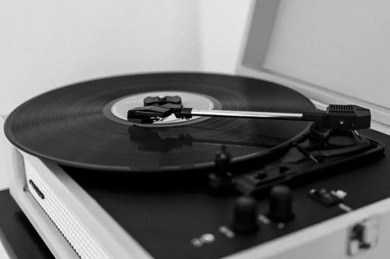 A monochrome photo of a vintage record player with a spinning vinyl record