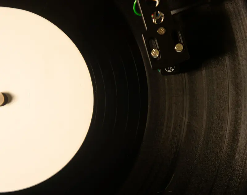 Vintage vinyl record player with close-up of needle on black gramophone, creating a nostalgic music vibe