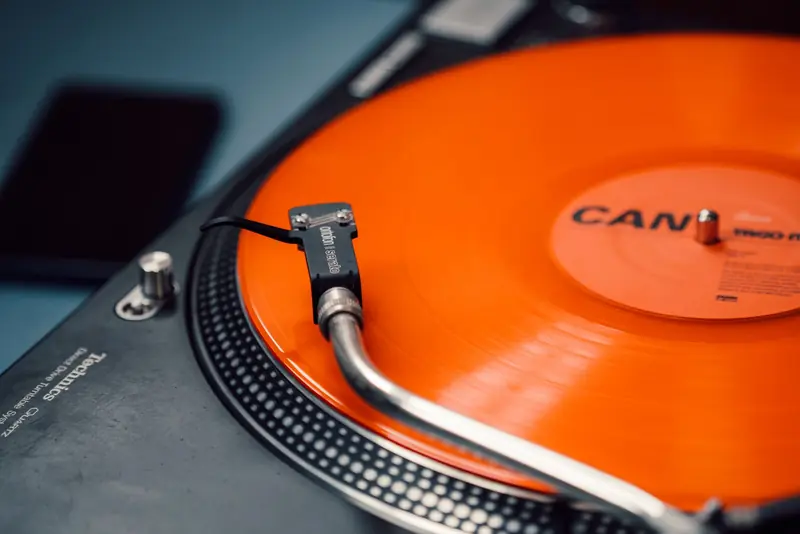 Close-up of a spinning orange vinyl record on a classic turntable