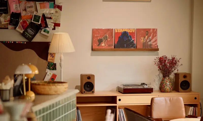 A quaint indoor setting with vintage decor, featuring a turntable and album records