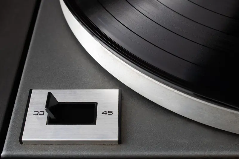 Macro shot of a vintage turntable with a speed selector for 33 and 45 RPM vinyl records