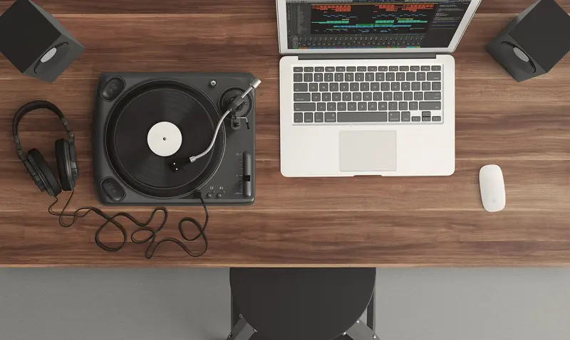 Top view of a music production desk with a laptop and turntable setup for modern audio production