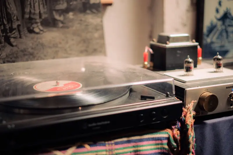 A cozy, vintage record player setup with an amplifier, tubes, and a nostalgic vibe